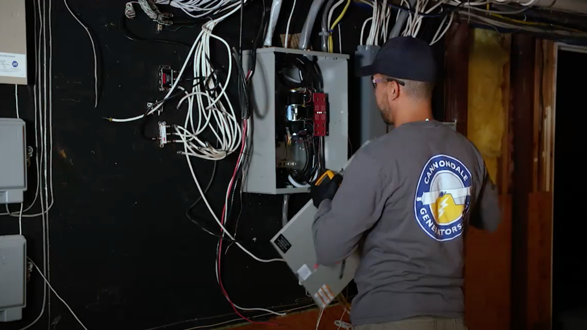 5 (5) Cannondale technician examining a home's electrical panel before generator installation.